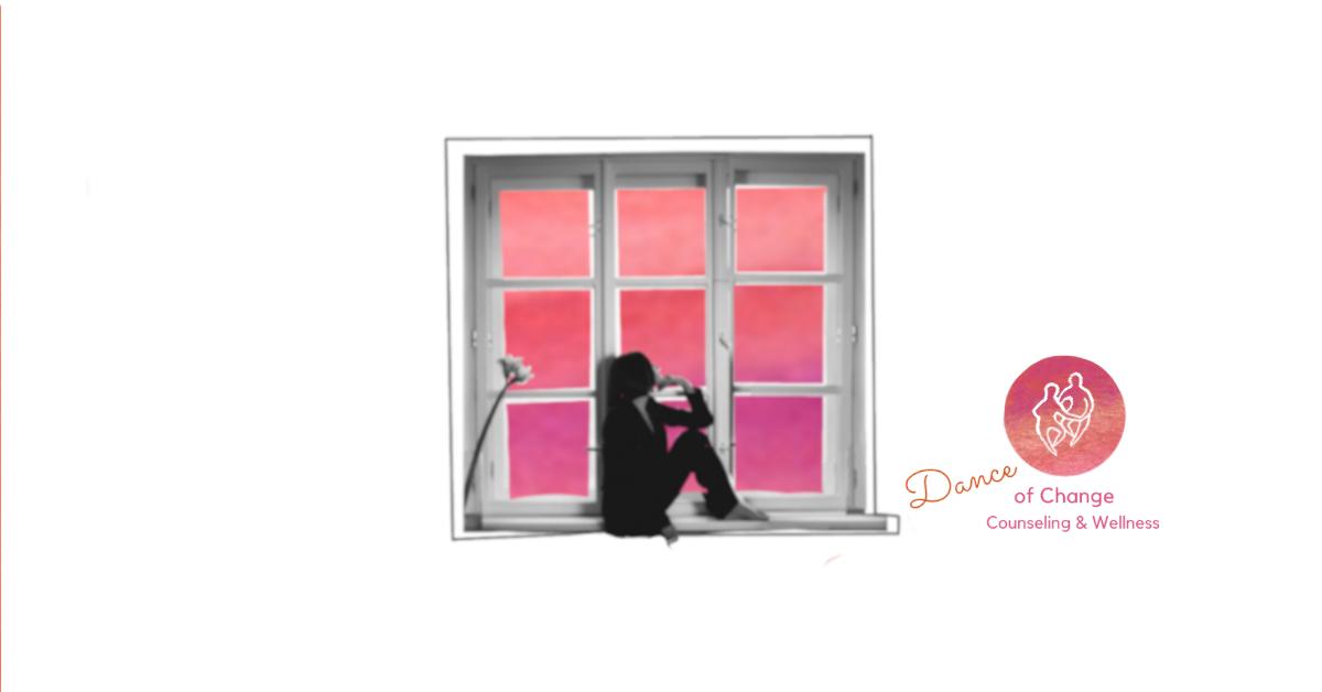 Woman sitting alone by a window in silhouette, reflecting themes of emotional pain, isolation, and healing through trauma therapy at Dance of Change Counseling & Wellness.